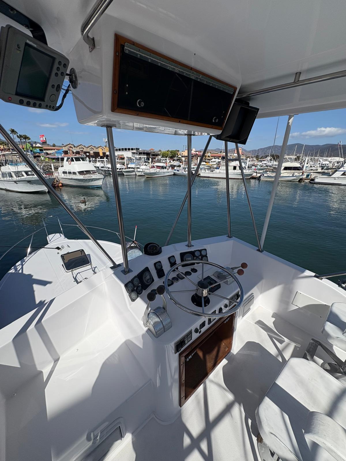 Flybridge helm with stainless wheel and marina view