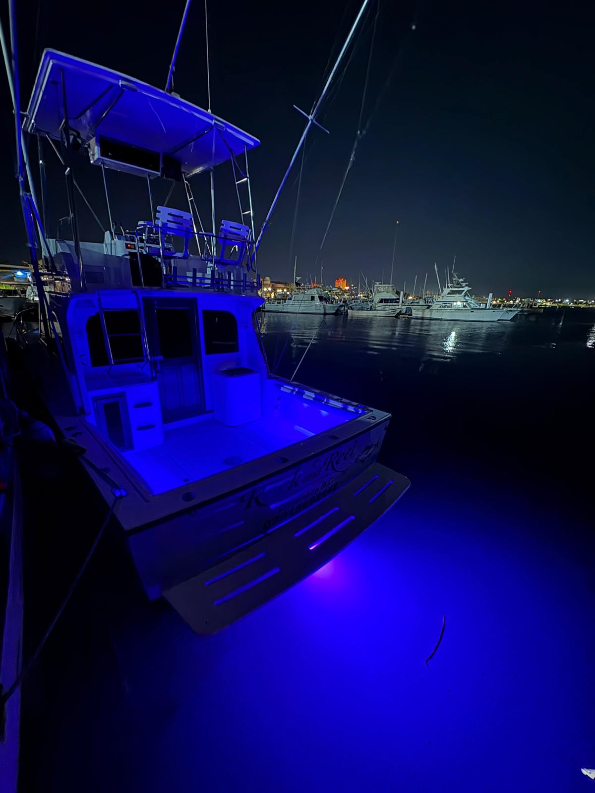 Sportfishing yacht at night with blue underwater lights